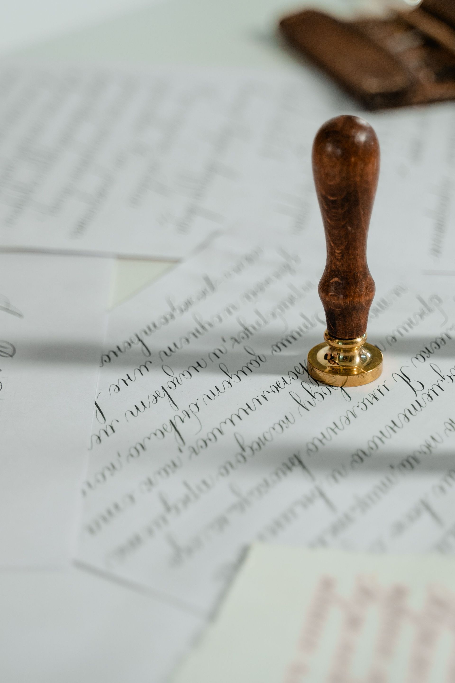 Vintage calligraphy papers with a wooden wax seal stamp, embodying timeless elegance.